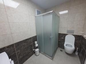 een badkamer met een toilet en een glazen douchecabine bij North Star Apart Trabzon in Yomra