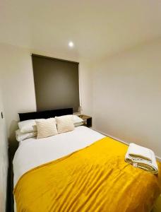 a bedroom with a large bed with a yellow blanket at The Light House in London