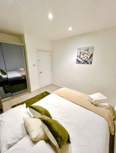 1 dormitorio con 1 cama blanca grande con almohadas verdes en The Light House en Londres