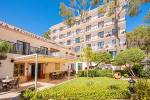 uma imagem da frente de um hotel com um jardim em Hotel Playa Mondrago em Porto Petro