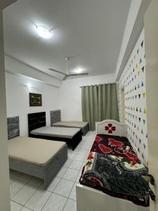 um pequeno quarto com 2 camas e uma janela em CareforU Hostel Al mankhool Burjman metro em Ghantoot