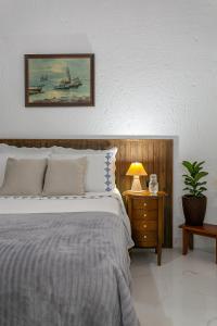 um quarto com uma cama e uma mesa com um candeeiro em RJ Residencial Beira Mar Deliciosa Casa Frente Mar na Pinheira com piscina em Pinheira