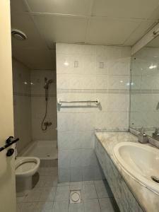 uma casa de banho com uma banheira, um WC e um lavatório. em CareforU Hostel Al mankhool Burjman metro em Ghantoot