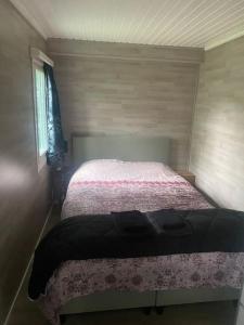 1 dormitorio con 1 cama en una habitación pequeña en Vakantie Bos Huisje “Meibloempje”, en Lanaken