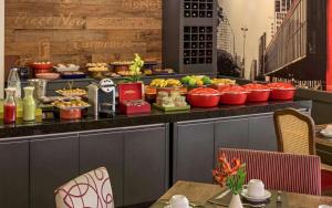 ein Buffet mit Speisen auf einem Tisch in einem Restaurant in der Unterkunft M-Flat Hotel Gold - Paulista in São Paulo