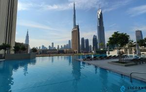 a swimming pool with a city skyline in the background at Brand New Modern 2BR Retreat, Walk to Dubai Mall - Downtown Views ll in Dubai