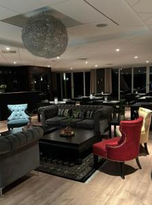 哈爾姆斯塔德的住宿－Hotell Toftalund，带沙发和椅子的客厅以及吊灯。