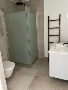 a bathroom with a shower and a toilet and a sink at Hotell Toftalund in Halmstad