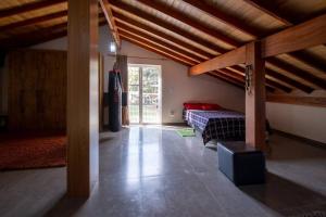um quarto com uma cama num quarto com tectos em madeira em Casa de Campo com lazer , pássaros e muito verde. em Poços de Caldas