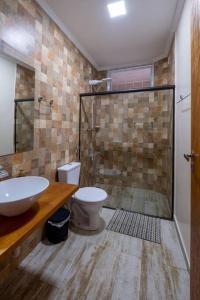 een badkamer met een douche, een toilet en een wastafel bij Casa de Campo com lazer , pássaros e muito verde. in Poços de Caldas