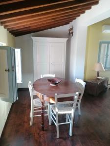 una sala da pranzo con tavolo in legno e sedie bianche di CASALE ANTONELLA a Bastia Umbra