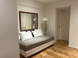 a bedroom with a bed with a mirror on the wall at Lindisimo en Recoleta in Buenos Aires