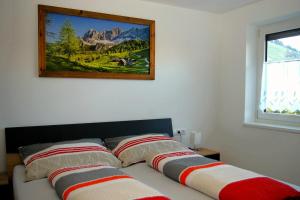 a bed with two pillows and a picture on the wall at Sellraintaler Auszeit 1 in Sellrain