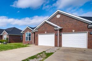 a brick house with two white garage doors at Bowling Green Duplex Rental about 5 Mi to Downtown! in Bowling Green