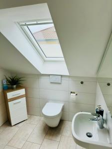 a bathroom with a toilet and a sink and a skylight at Modern Wohnen mit SmartTV, Arbeitsplatz und Küche in Bad Oeynhausen