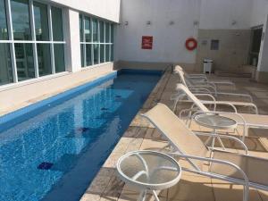 a row of chairs sitting next to a swimming pool at Saint Moritz Diária Brasil 63873 in Brasilia