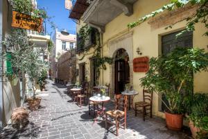 an alley with tables and chairs on a street at Ifigenia Rooms in Chania