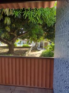 Una cerca con un árbol y una acera detrás de él. en Casa Girassol, en Itaparica