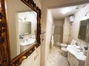 シエナにあるAppartamento Mimosaのバスルーム(鏡、洗面台2台、トイレ付)
