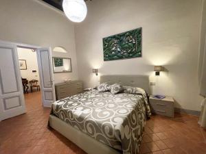 シエナにあるAppartamento Mimosaのベッドルーム1室(ベッド1台付)が備わります。壁には絵画が飾られています。