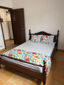 um quarto com uma cama com uma estrutura em madeira em Pousada Mar Suites Toninhas em Ubatuba