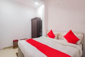 a bedroom with a large bed with red pillows at OYO Royal Inn Near Phoenix United Lucknow in Charbagh