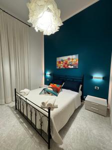 um quarto com uma cama com uma parede azul em Cavour Holidays em Cefalù