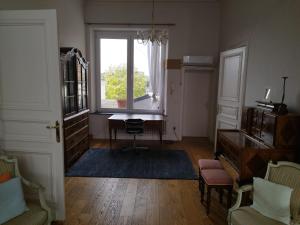 - un salon avec une fenêtre et un bureau dans l'établissement Antique appartement au centre d'Andenne, à Andenne