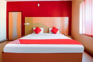 um quarto vermelho com uma cama grande e almofadas vermelhas em Flagship Hotel Samar Palace em Jaipur