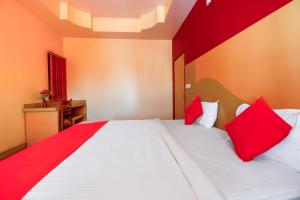 um quarto com uma cama grande e almofadas vermelhas em Flagship Hotel Samar Palace em Jaipur