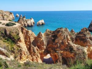 a view of the ocean with rocks in the water at Quinta Nova Apartment by Trip2Portugal in Alvor