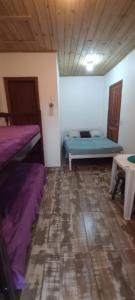 um quarto com duas camas e uma mesa em Os Passarinhos B.I. em Barra de Ibiraquera