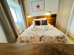 Schlafzimmer mit einem großen Bett mit einem Kopfteil aus Holz in der Unterkunft Bienvenue au Cœur d’Alsace-centre Obernai -4 pers in Obernai