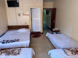 Zimmer mit 2 Betten und einer Tür zu einem Zimmer in der Unterkunft Addis Guest House Djibouti in Dschibuti