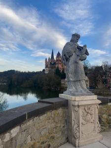 a statue on a bridge with a castle in the background at Charmante Ferienwohnung Limburg in Limburg an der Lahn