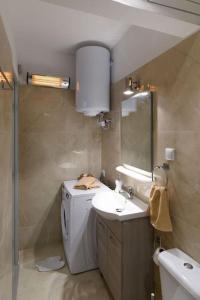 een badkamer met een wastafel en een wasmachine bij andromachis house 1 in Volos