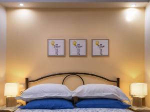 een slaapkamer met een bed met drie foto's aan de muur bij andromachis house 1 in Volos