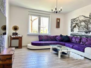 sala de estar con sofá púrpura y mesa en Maribor Central Apartment (Garden + Free Parking) en Maribor
