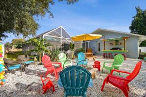 a group of colorful chairs and tables in a yard at Luxury heated-pool home blocks from the beach in Tarpon Springs