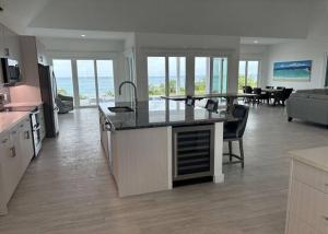 a kitchen and living room with a view of the ocean at Twin Coves Tranquility: Private Beachfront Estate in North Palmetto Point