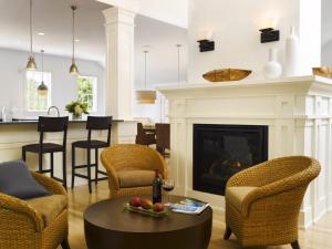 sala de estar con chimenea, mesa y sillas en White Elephant Hotel, en Nantucket