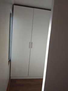un gran armario blanco en una habitación con suelo de madera en casa Galilea, en Rancagua