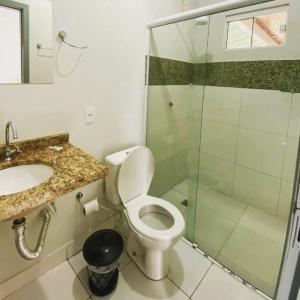 a bathroom with a toilet and a glass shower at PRINCIPE HOTEL in Sorriso