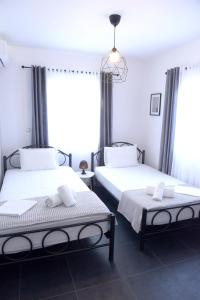 twee bedden in een kamer met twee ramen bij Tolis home kanali in Kanali