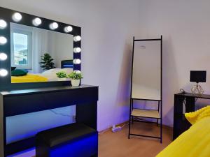 1 dormitorio con espejo, 1 cama y 1 silla en 2 Zimmer Wohnung, Küche, Bad, Balkon, Tiefgarage, Netflix, en Alzey