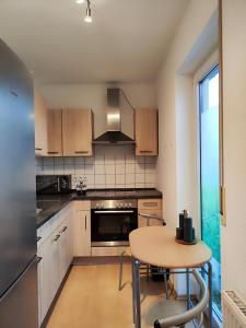 een keuken met een tafel, een fornuis en een koelkast bij 2 Zimmer Wohnung, Küche, Bad, Balkon, Tiefgarage, Netflix in Alzey
