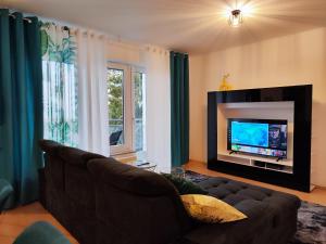 een woonkamer met een bank en een flatscreen-tv bij 2 Zimmer Wohnung, Küche, Bad, Balkon, Tiefgarage, Netflix in Alzey