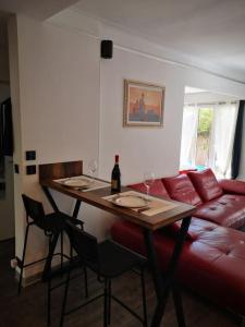 ein Wohnzimmer mit einem Tisch und einer roten Couch in der Unterkunft Cannes Cosy Oasis in Cannes + 1 Foto