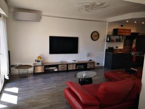 ein Wohnzimmer mit einem roten Sofa und einem Flachbildfernseher in der Unterkunft Cannes Cosy Oasis in Cannes