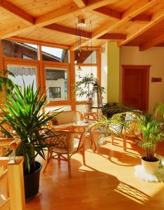 a room with a table and chairs and plants at Lehnerhof in Grossraming